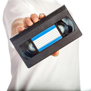 Video tape cassete (VHS) with blue label hold by male hand